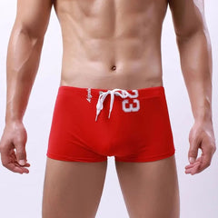 a hot gay man in red Men's 23 Bowtie Swim Trunks - pridevoyageshop.com - gay men’s underwear and swimwear