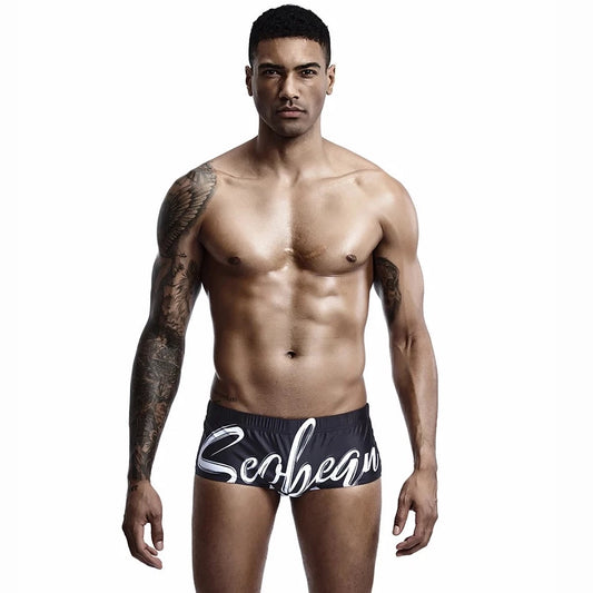 a hot gay man in black Alphabet Splash Square Cut Swim Trunks - pridevoyageshop.com - gay men’s underwear and swimwear