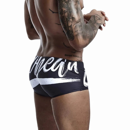 a hot gay man in black Alphabet Splash Square Cut Swim Trunks - pridevoyageshop.com - gay men’s underwear and swimwear