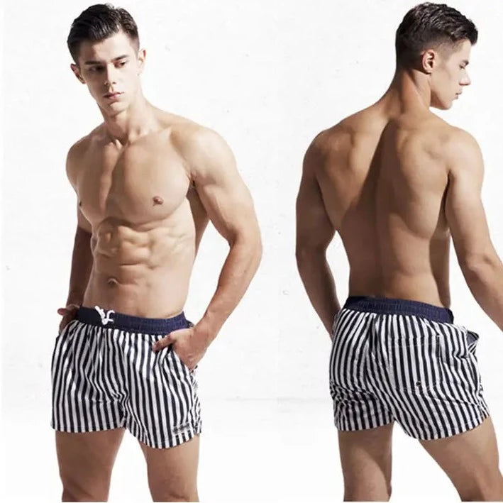 a hot gay man in White + Navy Blue Desmiit Vertical Striped Board Shorts - pridevoyageshop.com - gay men’s underwear and swimwear
