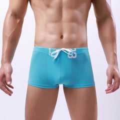 a hot gay man in sky blue Men's 23 Bowtie Swim Trunks - pridevoyageshop.com - gay men’s underwear and swimwear
