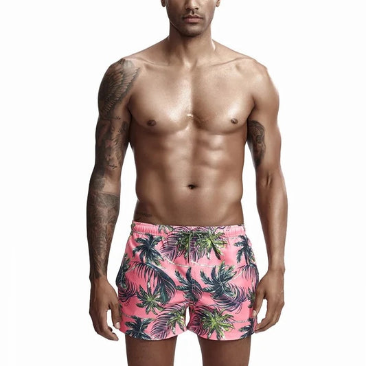 a hot gay man in pink Palm Trees Board Shorts - pridevoyageshop.com - gay men’s underwear and swimwear