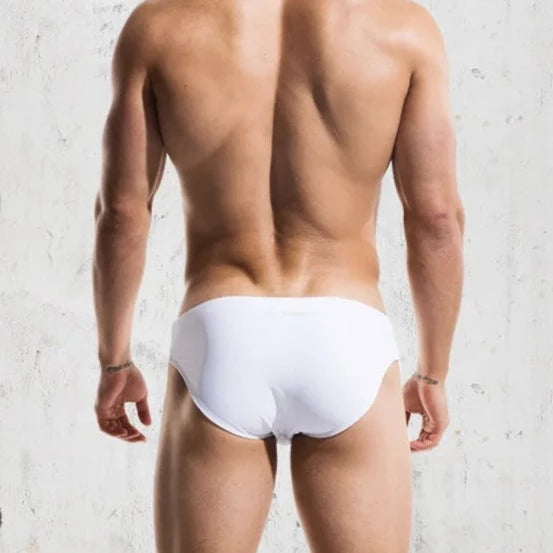 a sexy gay man in white DESMIIT Solid Color Swim Briefs - pridevoyageshop.com - gay men’s underwear and swimwear