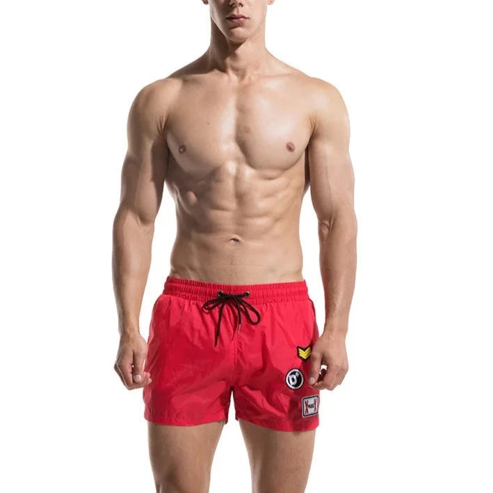 a hot gay man in red Desmiit Travelers Board Shorts - pridevoyageshop.com - gay men’s underwear and swimwear