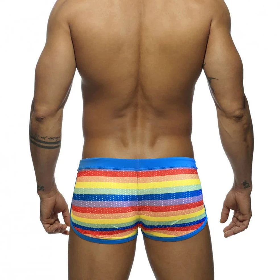 a hot gay man in Rainbow Striped Mesh Square Cut Swim Trunks - pridevoyageshop.com - gay men’s underwear and swimwear