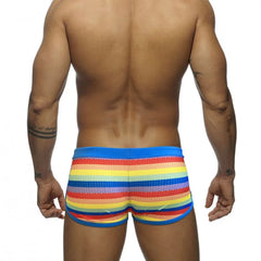 a hot gay man in Rainbow Striped Mesh Square Cut Swim Trunks - pridevoyageshop.com - gay men’s underwear and swimwear