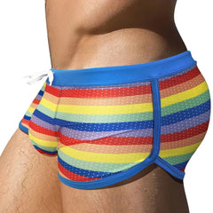 a hot gay man in Rainbow Striped Mesh Square Cut Swim Trunks - pridevoyageshop.com - gay men’s underwear and swimwear