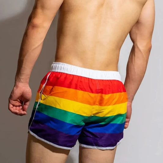 a hot gay man in DM Rainbow Swim Trunks - pridevoyageshop.com - gay men’s underwear and swimwear