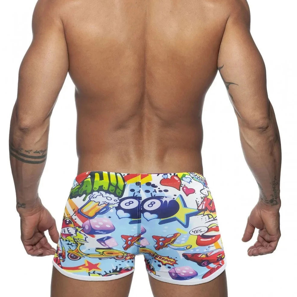 a hot gay man in Pop Art Plunge Swim Trunks - pridevoyageshop.com - gay men’s underwear and swimwear