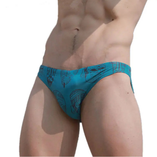 a sexy man in Teal Totem Men’s Poolside Rites Swim Briefs - pridevoyageshop.com - gay men’s sexy swim briefs, trunks, board shorts, and bikinis
