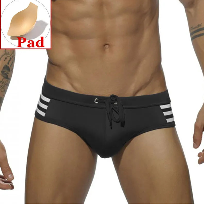 a sexy man in black Men’s Striped Stallion Low Rise Swim Briefs with pad - pridevoyageshop.com - gay men’s sexy swim briefs, trunks, board shorts, and bikinis