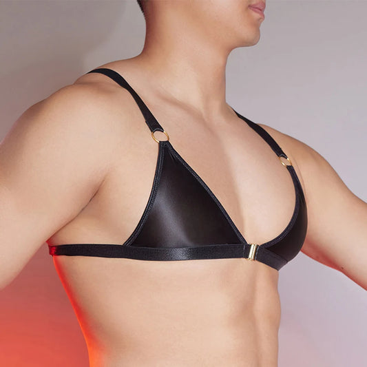 a sexy man in black faux-leather bralette with front clasp, shiny finish hugging chest and showing pecs and straps – pridevoyageshop.com – gay men’s harness, lingerie and fetish wear