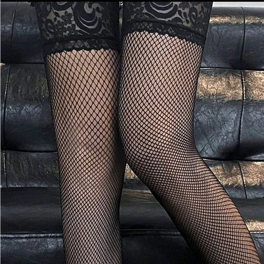 a sexy man in black lace-top midnight net fishnets serving seductive femme dom energy – pridevoyageshop.com – gay men’s harness, lingerie and fetish wear