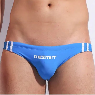 a sexy man in blue Men’s Fast & Curious Skinny Swim Briefs - pridevoyageshop.com - gay men’s sexy swim briefs, trunks, board shorts, and bikinis