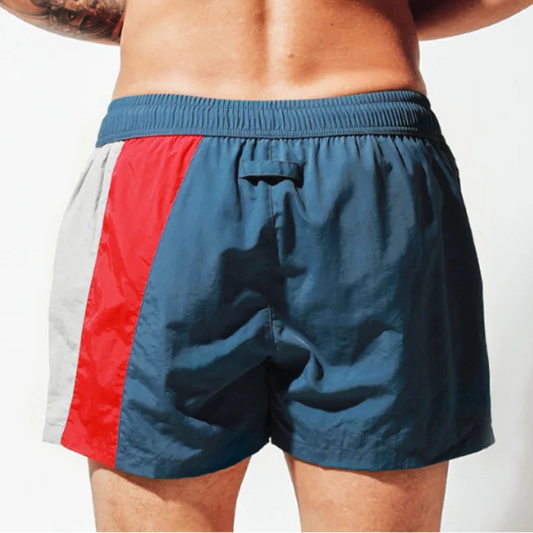 a sexy man in blue Men’s Signal Swim Beach Board Shorts – pridevoyageshop.com – gay men’s sexy swim briefs, trunks, board shorts, and bikinis