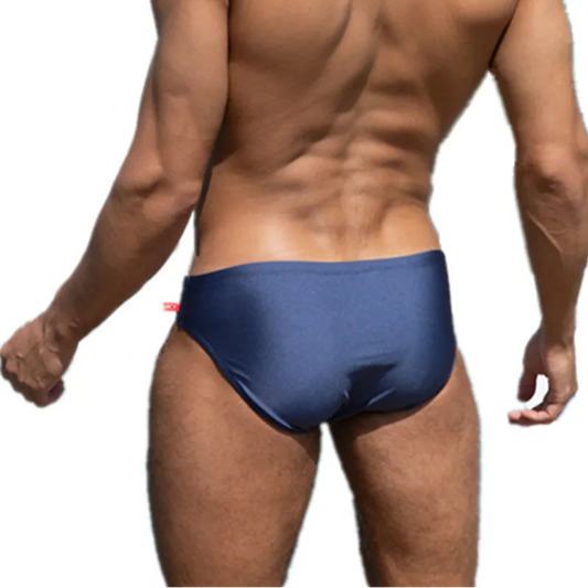 a sexy man in dark blue Men’s Tease-Me Minimal Swim Briefs - pridevoyageshop.com - gay men’s sexy swim briefs, trunks, board shorts, and bikinis