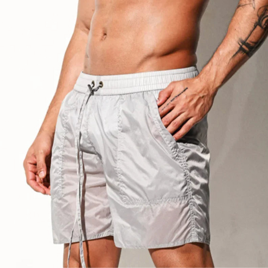a sexy man in light gray Men’s Cellblock Sheen Swim Short – pridevoyageshop.com – gay men’s sexy swim briefs, trunks, board shorts, and bikinis