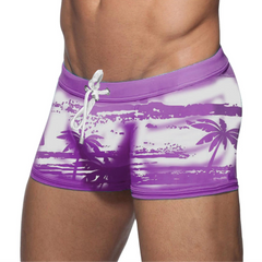 a sexy man in purple Men’s Holiday Hung Swim Trunks- pridevoyageshop.com - gay men’s sexy swim briefs, trunks, board shorts, and bikinis
