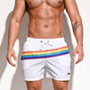 a sexy man in white Men’s Werk the Rainbow Volley Pride Board Shorts – pridevoyageshop.com – gay men’s sexy swim briefs, trunks, board shorts, and bikinis