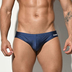 A sexy man in dark blue Desmiit Men’s Bulge Master Low Rise Swim Briefs - pridevoyageshop.com - gay men’s sexy swim briefs, trunks, board shorts, and bikinis