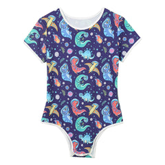 Gaylaxy Dinos Daddy’s Boy Printed Onesie laid flat, stretchy cartoon fabric, cute bold print, snap-front playful cut – pridevoyageshop.com – gay men’s harness, lingerie and fetish wear