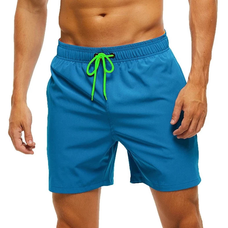 a hot gay man in peacock blue Solid Color Pocketed Board Shorts - pridevoyageshop.com - gay men’s underwear and swimwear