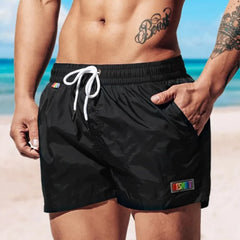 a hot gay man in black Desmiit Rainbow Pride Pocket Board Shorts - pridevoyageshop.com - gay men’s underwear and swimwear