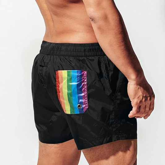 a hot gay man in black Desmiit Rainbow Pride Pocket Board Shorts - pridevoyageshop.com - gay men’s underwear and swimwear