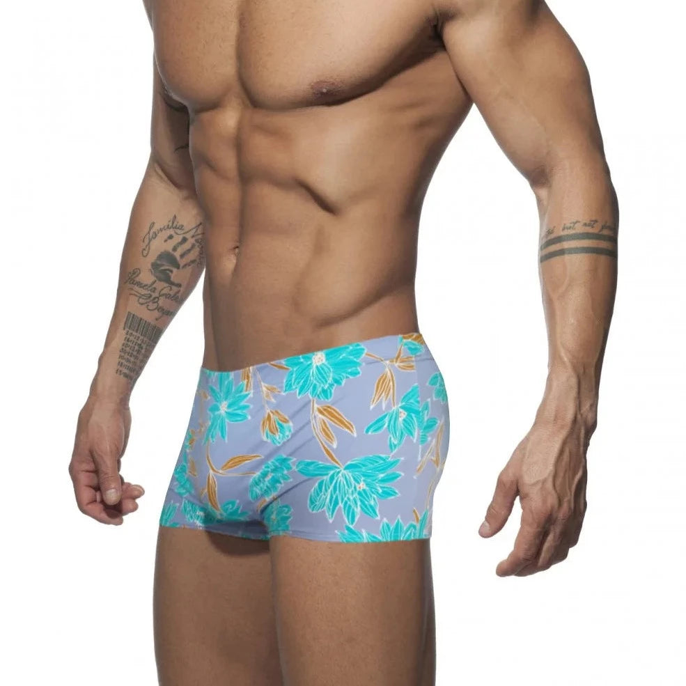 a hot gay man in blue Bold Neon Forest Swim Trunks - pridevoyageshop.com - gay men’s underwear and swimwear