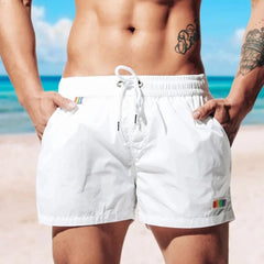 a hot gay man in white Desmiit Rainbow Pride Pocket Board Shorts - pridevoyageshop.com - gay men’s underwear and swimwear