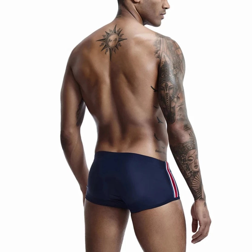 a hot gay man in navy Bold Stripe Swim Trunks - pridevoyageshop.com - gay men’s underwear and swimwear