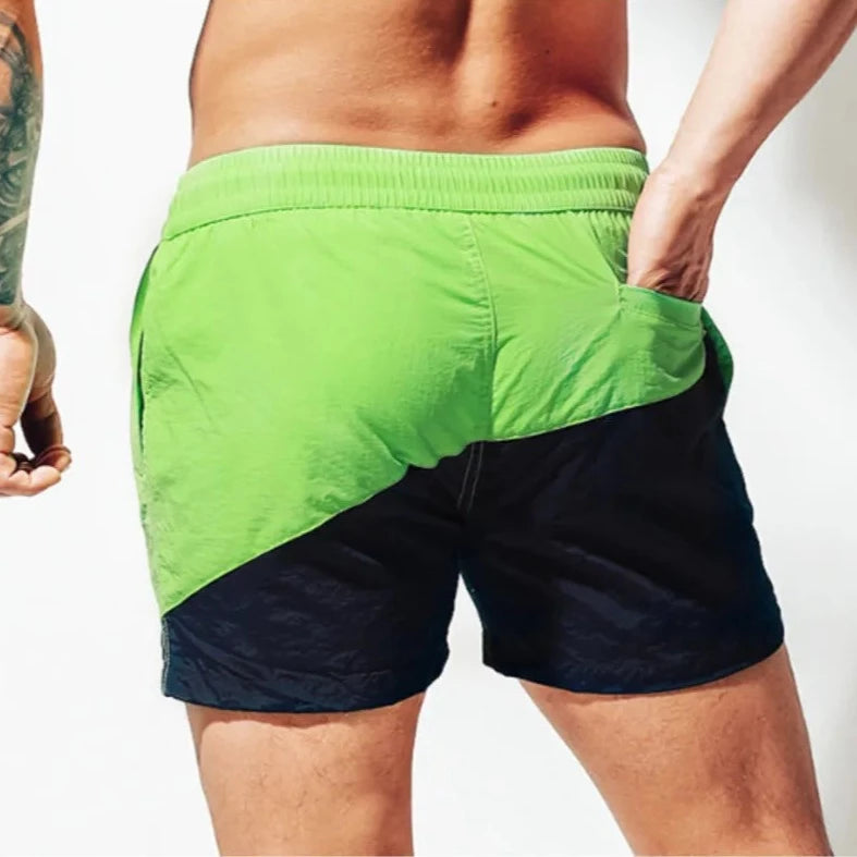 a hot guy in green Tidal Charm Two Toned Board Shorts - pridevoyageshop.com - gay men’s underwear and swimwear