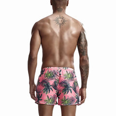 a hot gay man in pink Palm Trees Board Shorts - pridevoyageshop.com - gay men’s underwear and swimwear