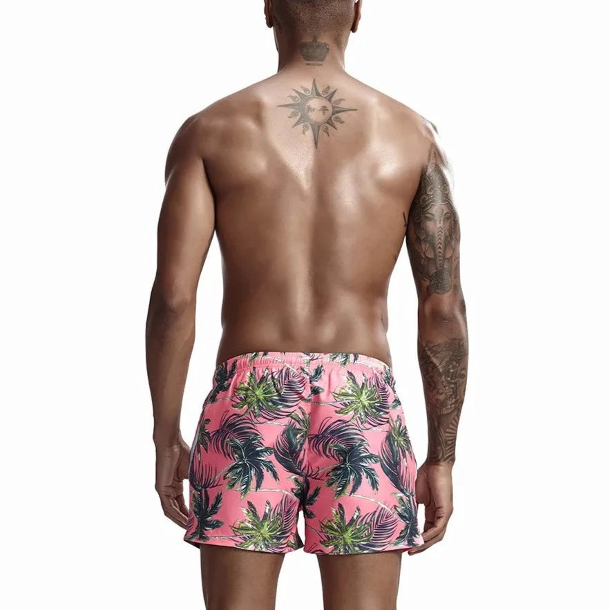 a hot gay man in pink Palm Trees Board Shorts - pridevoyageshop.com - gay men’s underwear and swimwear