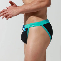 a sexy gay man in black Desmiit Bowtie High Leg Swim Briefs - pridevoyageshop.com - gay men’s underwear and swimwear