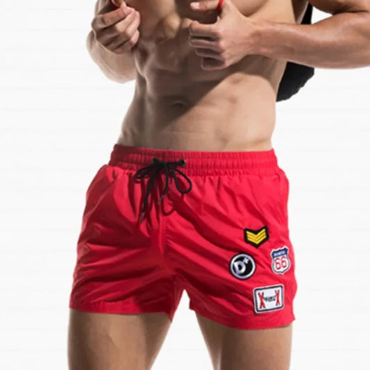 a hot gay man in red Desmiit Travelers Board Shorts - pridevoyageshop.com - gay men’s underwear and swimwear