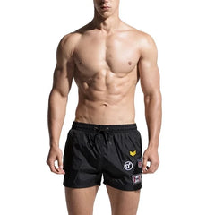 a hot gay man in black Desmiit Travelers Board Shorts - pridevoyageshop.com - gay men’s underwear and swimwear