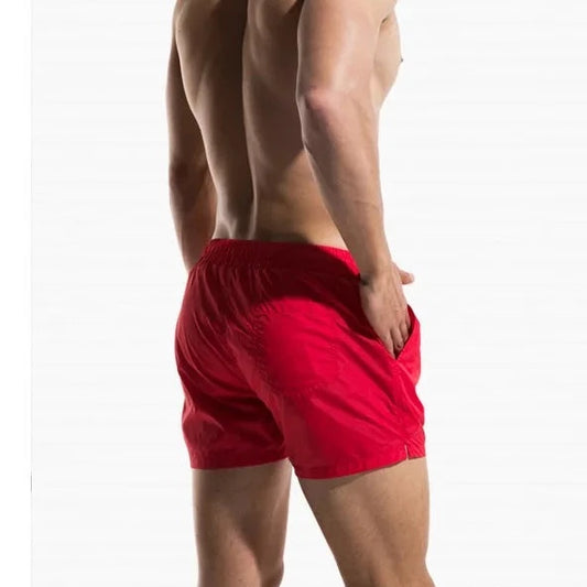 a hot gay man in red Desmiit Travelers Board Shorts - pridevoyageshop.com - gay men’s underwear and swimwear