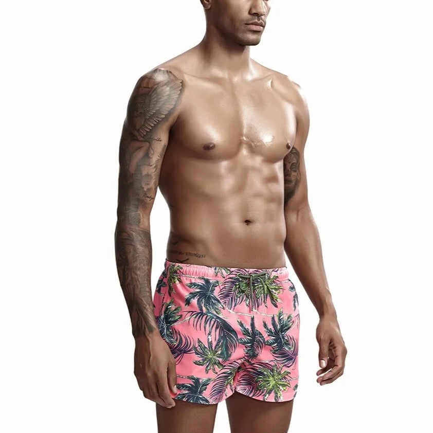 a hot gay man in pink Palm Trees Board Shorts - pridevoyageshop.com - gay men’s underwear and swimwear