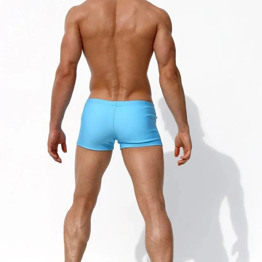 a hot gay man in lake blue Solid Color Bowtie Swim Trunks - pridevoyageshop.com - gay men’s underwear and swimwear