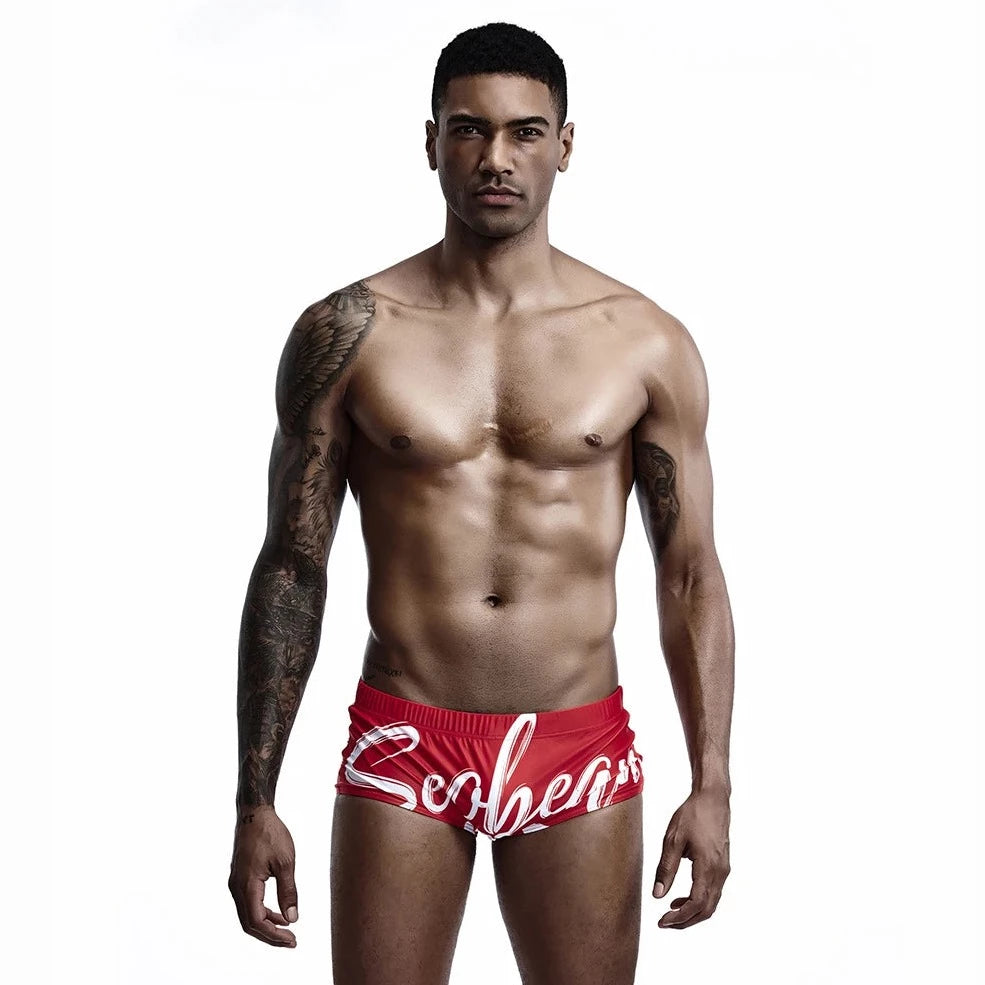 a hot gay man in red Alphabet Splash Square Cut Swim Trunks - pridevoyageshop.com - gay men’s underwear and swimwear
