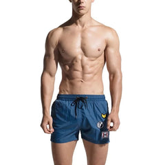 a hot gay man in blue Desmiit Travelers Board Shorts - pridevoyageshop.com - gay men’s underwear and swimwear