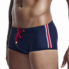 a hot gay man in navy Bold Stripe Swim Trunks - pridevoyageshop.com - gay men’s underwear and swimwear