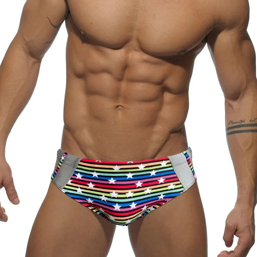 a hot gay man in Men's Rainbow Star Striped Swim Briefs - pridevoyageshop.com - gay men’s underwear and swimwear