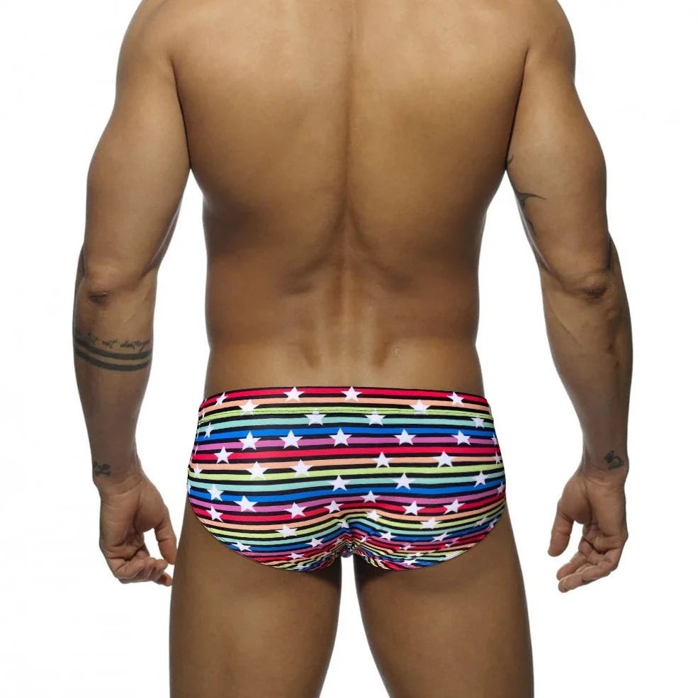 a hot gay man in Men's Rainbow Star Striped Swim Briefs - pridevoyageshop.com - gay men’s underwear and swimwear