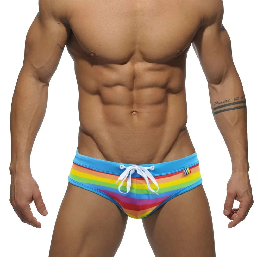 a sexy gay man in Drawstring Rainbow Swim Briefs - pridevoyageshop.com - gay men’s underwear and swimwear