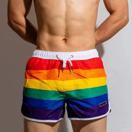 a hot gay man in DM Rainbow Swim Trunks - pridevoyageshop.com - gay men’s underwear and swimwear