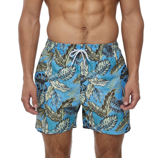 a hot gay man in blue Palm Leaves Board Shorts - pridevoyageshop.com - gay men’s underwear and swimwear