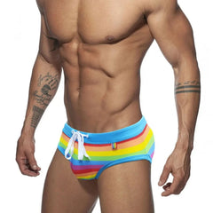 a sexy gay man in Drawstring Rainbow Swim Briefs - pridevoyageshop.com - gay men’s underwear and swimwear