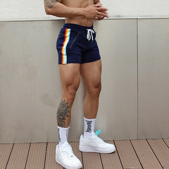 sexy gay man in drak blue Rainbow Striped Gym Booty Shorts | Gay Shorts - Men's Activewear, gym short, sport shorts, running shorts- pridevoyageshop.com